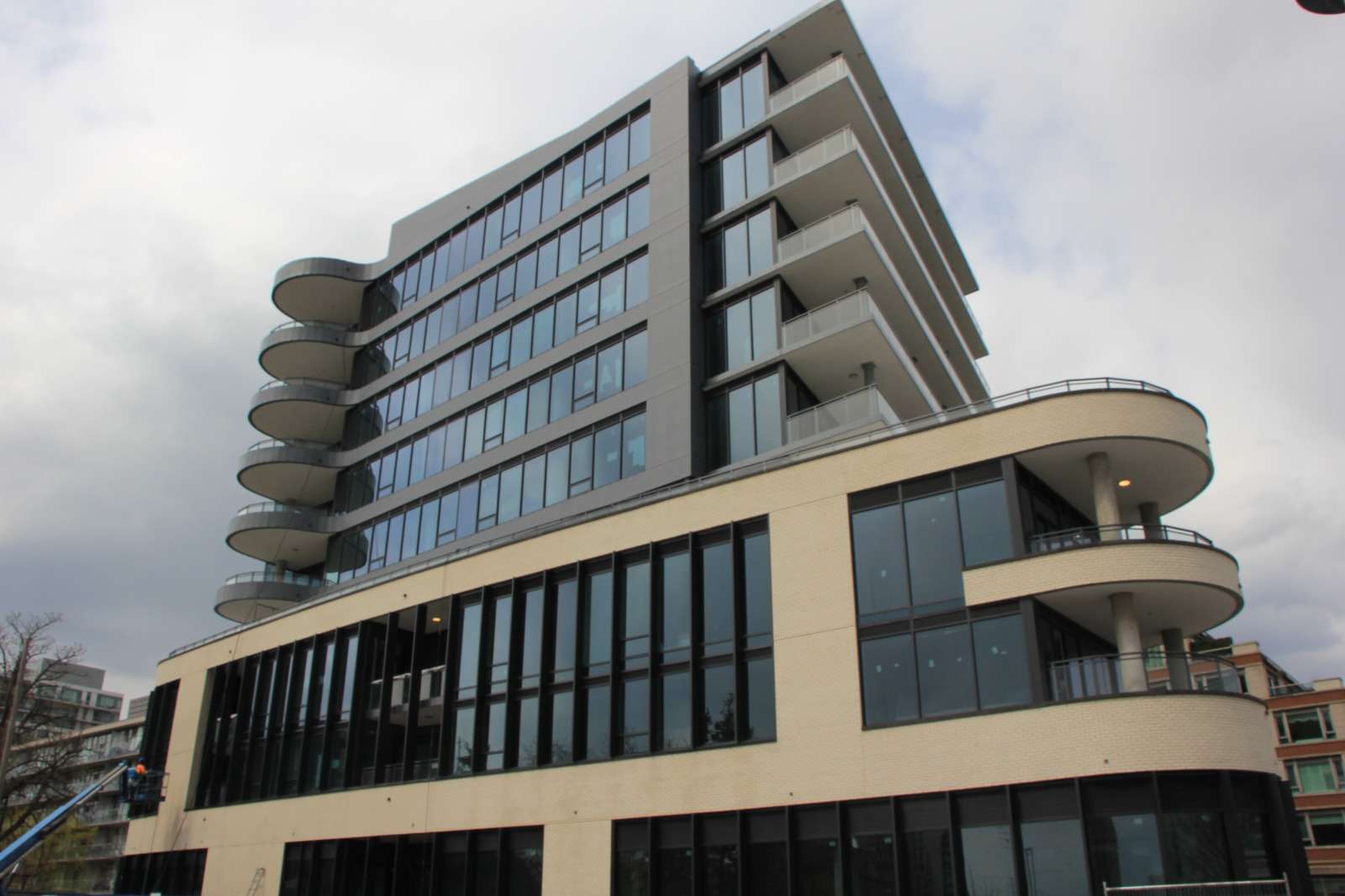 Exterior of 55 Port Street East in Mississauga, a mid-rise condominium with curved glass balconies